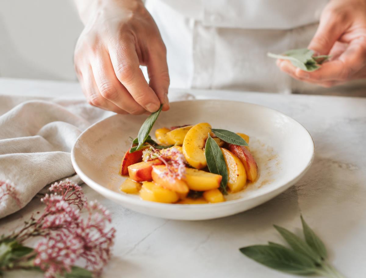 Chef emplatando fruta con hojas de salvia